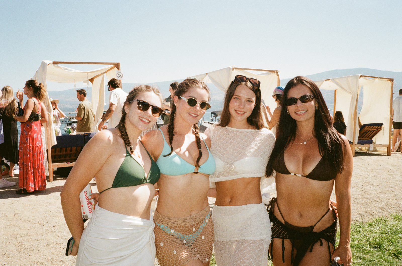 Stylish friends smiling by the lake in the sun
