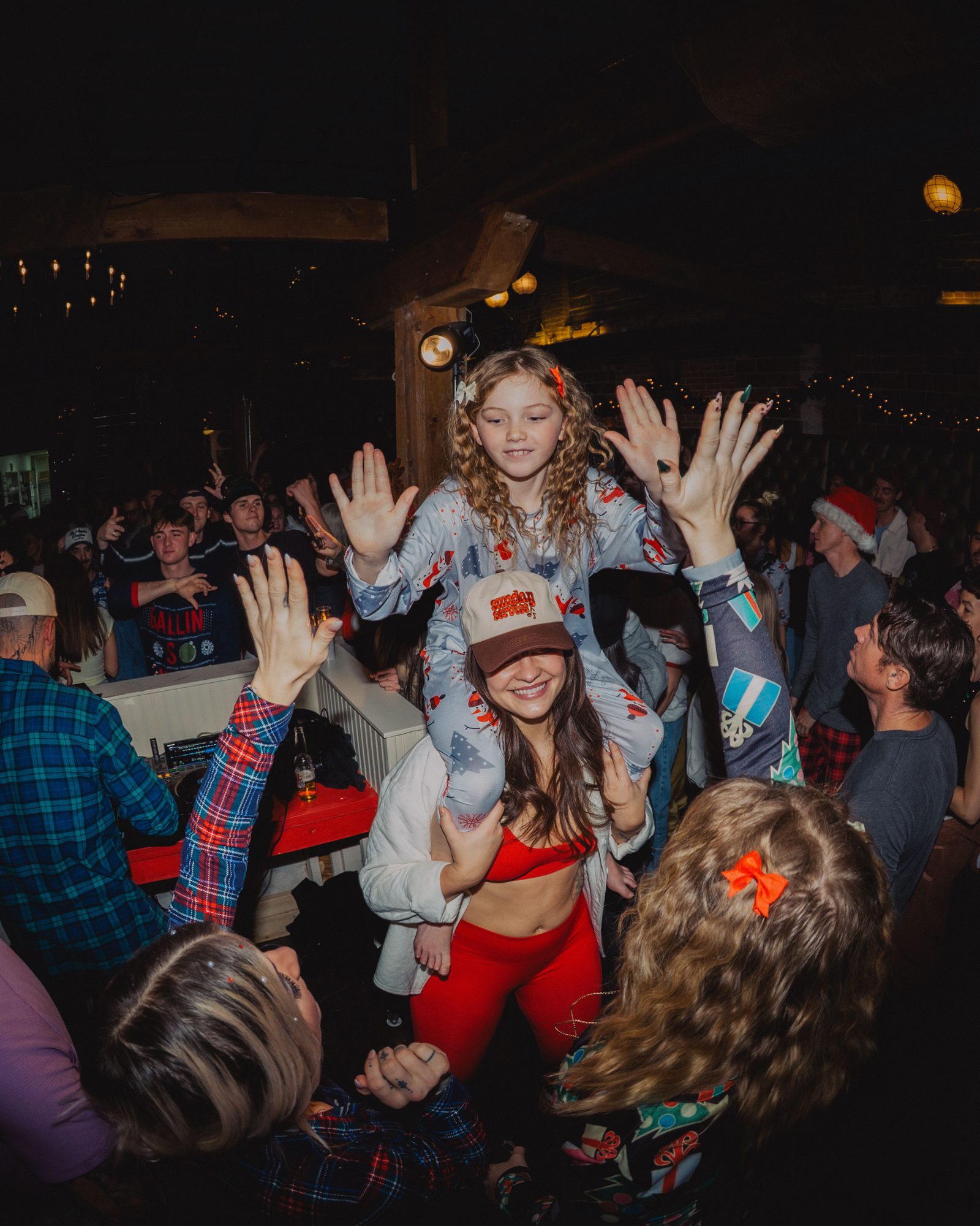 A hands-up crowd at an indoor Sunday Service set